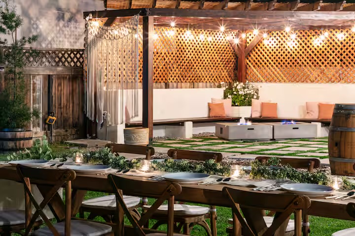 Outdoor dining under cedar pergola with string lights at sunset